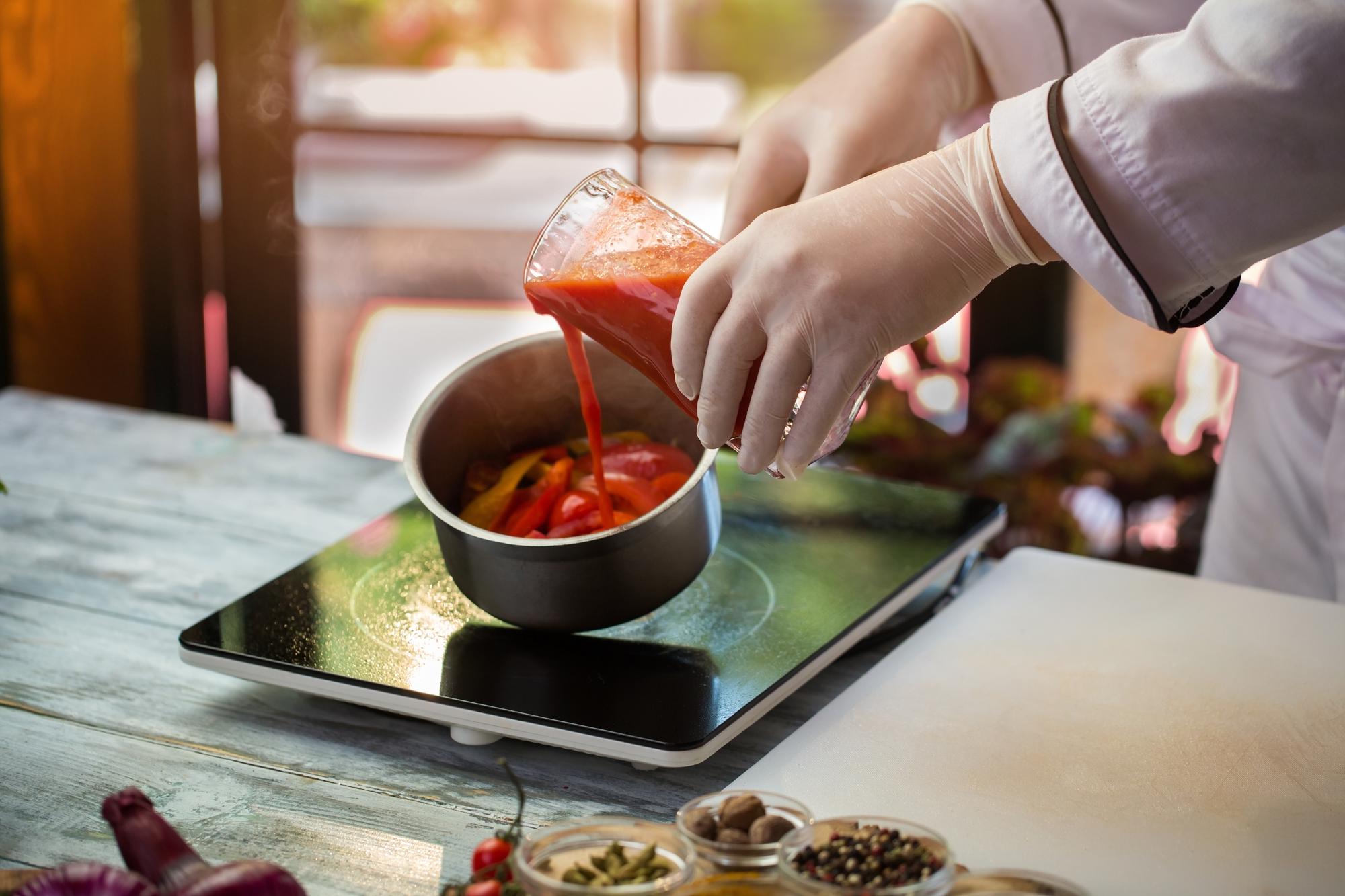 Close-up of chef hands preparing sauce